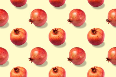 Sarı zemin üzerinde kusursuz olgun kırmızı sağlıklı nar deseni.