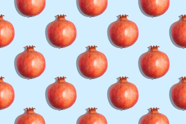 Mavi zemin üzerinde yarım olgunlaşmış kırmızı nar deseni.