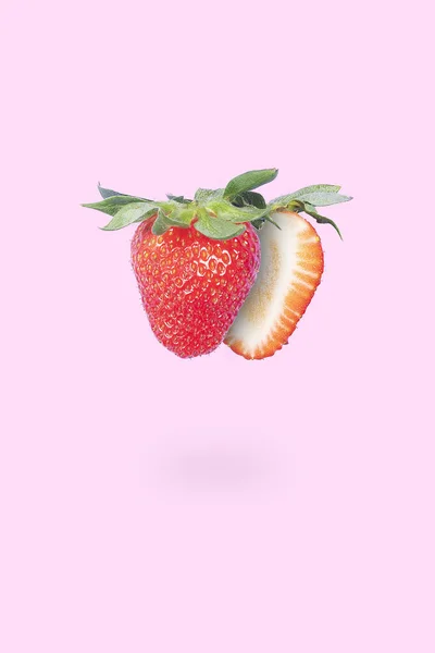 재활용 딸기를 반으로 분홍색 배경에 초록색 — 스톡 사진