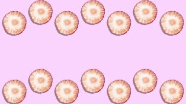 Hareket Animasyonunu Durdur. Olgun sulu çilek dilimleri pembe arkaplan fotokopi alanı üzerinde yukarıdan ve aşağıdan bir dalga şeklinde hareket eder