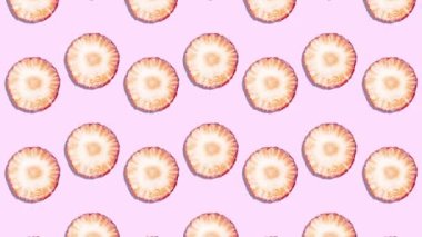 Hareket Animasyonunu Durdur. Olgun sulu çilek dilimleri pembe arka planda bir aşağı bir yukarı hareket eder.