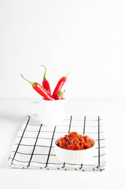 Baharatlı ev yapımı harissa ya da acı biber sosu, kimyon, kırmızı biberli kişniş ve beyaz bir peçetede beyaz bir peçetede tereyağlı biber.