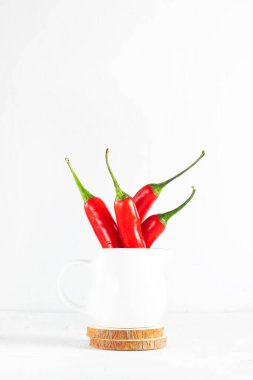 Bir sürü acı biber beyaz krema içinde ahşap bardak altlıklarında yüksek anahtarda