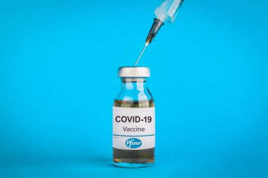 İzmir, Türkiye / 11 Ağustos 2020: Coronavirus aşısı kavramı ve geçmişi. Yeni aşı pfizer ve biyoteknoloji mavi arka planda izole edildi. Covid-19, 2019-nCov salgını.