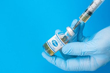 İzmir, Türkiye / 11 Ağustos 2020: Coronavirus aşısı kavramı ve geçmişi. Yeni aşı pfizer ve biyoteknoloji mavi arka planda izole edildi. Covid-19, 2019-nCov salgını.