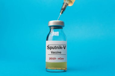Coronavirus aşısı konsepti ve geçmişi. Yeni sputnik-v aşısı mavi arka planda izole edildi. Covid-19, 2019-nCov salgını.