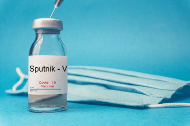 Coronavirus aşısı konsepti ve geçmişi. Yeni sputnik-v aşısı mavi arka planda izole edildi. Covid-19, 2019-nCov salgını.