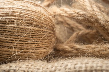 Doğal jüt iplik rulosuyla doğal keten kumaşa izole edilmiş makro manzara