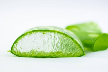 Beyaz arka planda dilimlenmiş yeşil aloe vera yaprağı. Doğal bitkisel bitki, cilt bakımı, sağlık ve güzellik merkezi konsepti. Görüntüyü kapat.