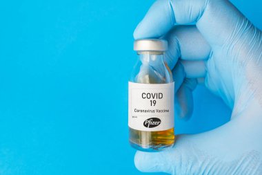 İzmir, Türkiye - 11 Ağustos 2020: Coronavirus aşısı kavramı ve geçmişi. Yeni aşı pfizer ve biyoteknoloji mavi arka planda izole edildi. Covid-19, 2019-nCov salgını.