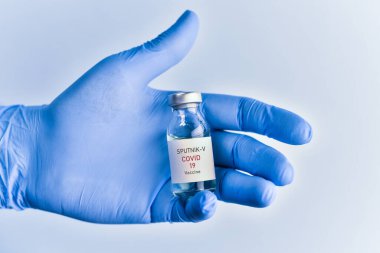 Coronavirus aşısı konsepti ve geçmişi. Yeni sputnik-v aşısı mavi arka planda izole edildi. Covid-19, 2019-nCov salgını.