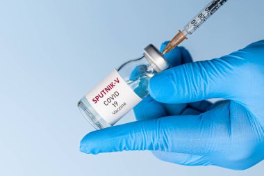 Coronavirus aşısı konsepti ve geçmişi. Yeni sputnik-v aşısı mavi arka planda izole edildi. Covid-19, 2019-nCov salgını.