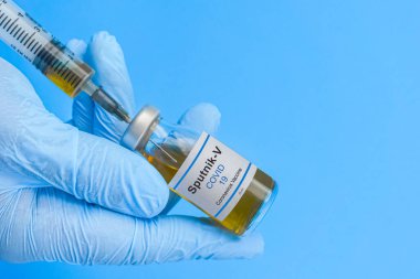 Coronavirus aşısı konsepti ve geçmişi. Yeni sputnik-v aşısı mavi arka planda izole edildi. Covid-19, 2019-nCov salgını.