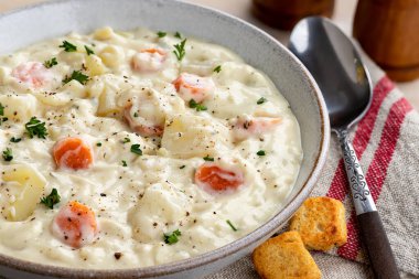 Bir kase kremalı patates ve kızarmış ekmekle havuç çorbası.