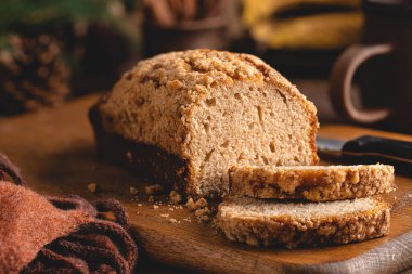 Köy tahtasında dilimlenmiş bir somun muzlu cevizli ekmek.