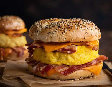 Kahvaltı sandviçi yumurta, pastırma ve peynirli simit üzerine.