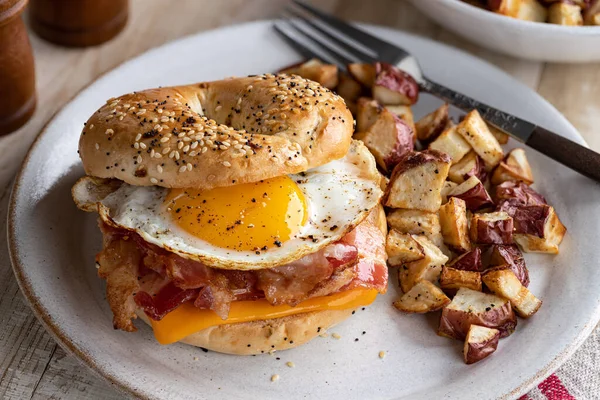 Bagel Breakfast Sandwich Fried Egg Bacon Cheese Plate Potatoes — Stock Photo, Image