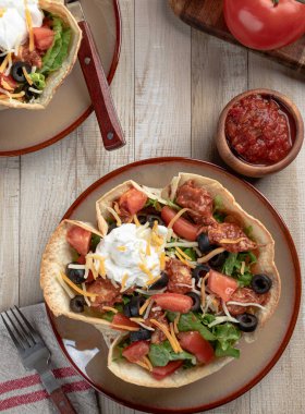 Tavuklu, marullu, domatesli, siyah zeytinli, peynirli ve ekşi kremalı tortilla kabuklu taco salatası.