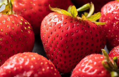 Taze olgun çilekler, grup halinde yakın çekim.