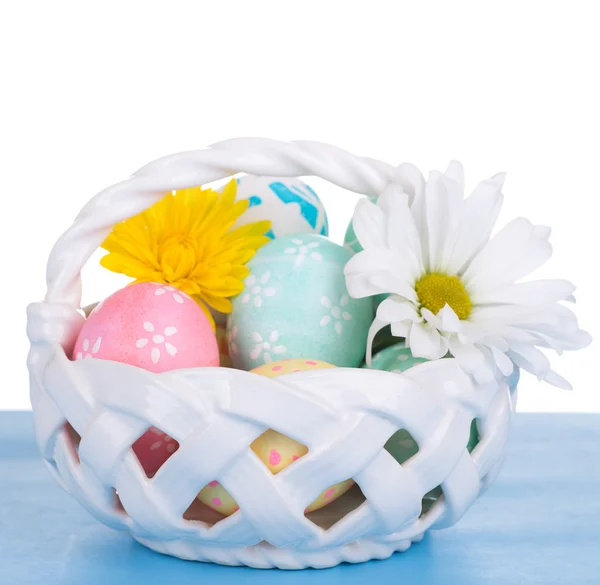 Huevos de Pascua en una canasta sobre fondo blanco — Foto de Stock