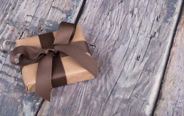 Подарок завернутый в коричневую бумагу — стоковое фото