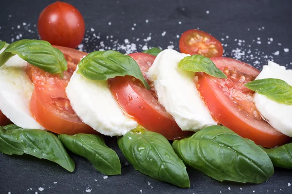 Insalata caprese su sfondo ardesia scura — Foto Stock