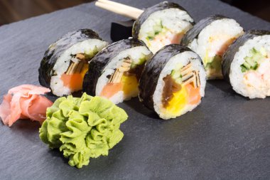 Koyu gri kayrak arka plan üzerinde taze suşi rulo