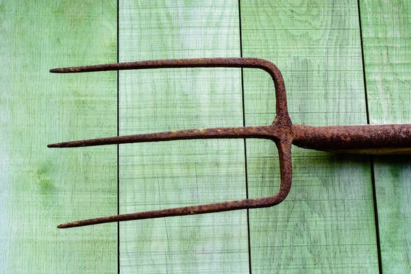 Forcone arrugginito su assi di legno — Foto Stock