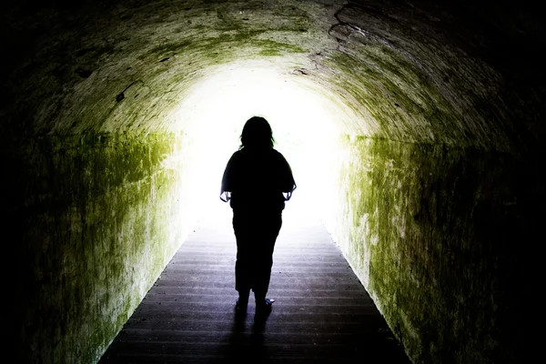 Siluett av kvinna i ljuset i tunneln Stockbild