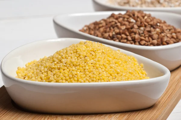 Raw millet groats in white bowl — Stock Photo, Image