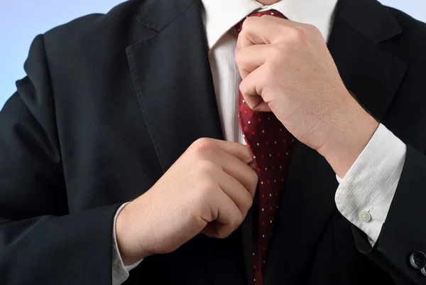 Businessman in suit adjusting his tie — Stock Photo, Image