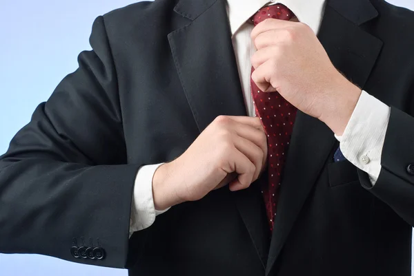 Businessman in suit adjusting his tie — Stock Photo, Image