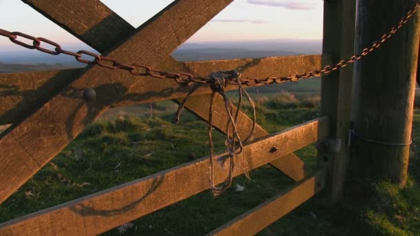 Abendlicht hebt eine Kette hervor, die an einem Tor in der Shropshire-Landschaft schwingt,. — Stockvideo