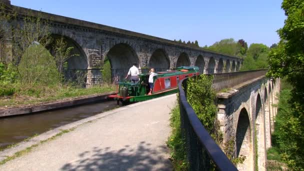 Canal barco en el canal de Llangollen y tren en viaducto en el acueducto de Chirk, Gales — Vídeo de stock