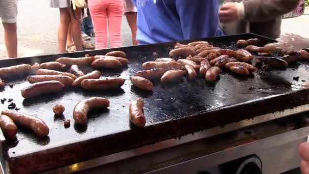 Sausages cooking on a griddle during the Ludlow 2012 Food Festival — Stock Video