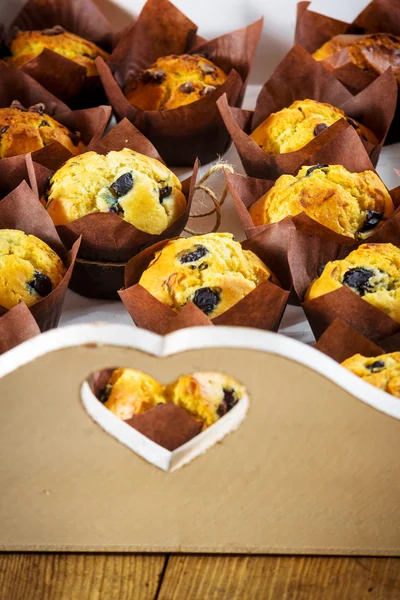 Grande quantidade de bolinhos doces muffins em uma bandeja com coração . — Fotografia de Stock