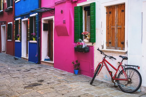 Zniszczone czasem rower pochylony kolorowy dom w Burano, Ita — Zdjęcie stockowe