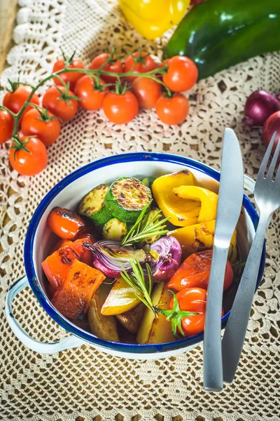 Fém, rusztikus edény egy fa asztal-szaftos grillezett zöldségekkel — Stock Fotó