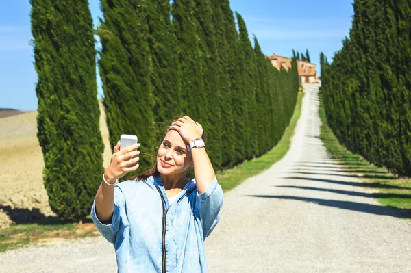 トスカーナ道路上で selfie を稼ぐ若い魅力的な女性 — ストック写真