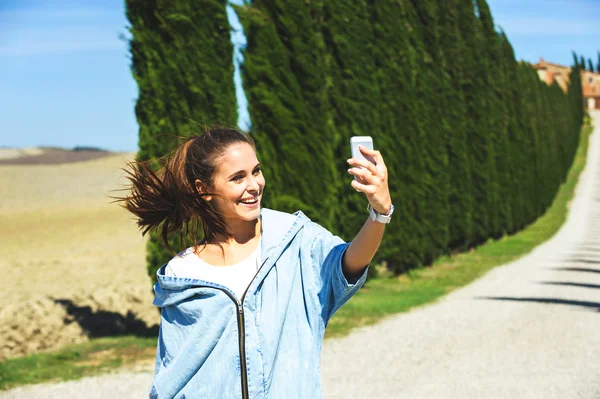 Jovem mulher atraente fazendo selfie na estrada da Toscana — Fotografia de Stock