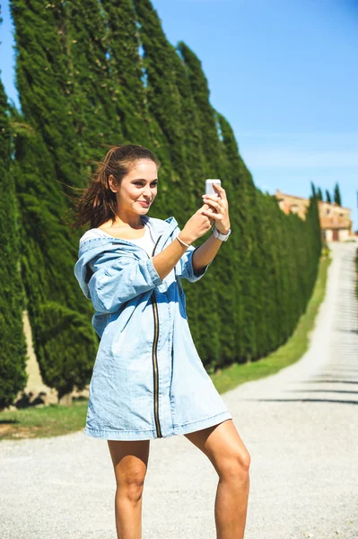 Jonge aantrekkelijke vrouw maken selfie Toscaanse onderweg — Stockfoto