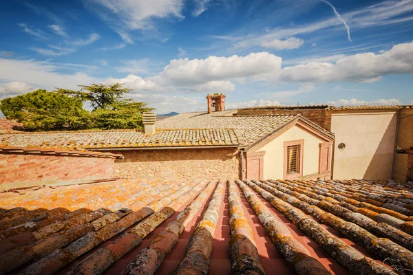 Fantastische bewolkte hemel over de rode daken. — Stockfoto