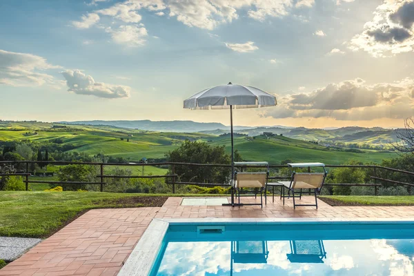 Liegestühle am Pool an einem warmen Tag bei Sonnenuntergang. — Stockfoto