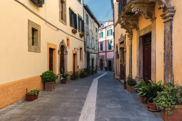 Calles de primavera de la antigua ciudad toscana. Flores de colores florecen y —  Fotos de Stock