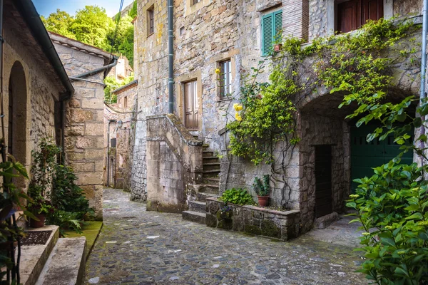 Jarní ulice starého toskánského města. Barevné květy kvetou — Stock fotografie
