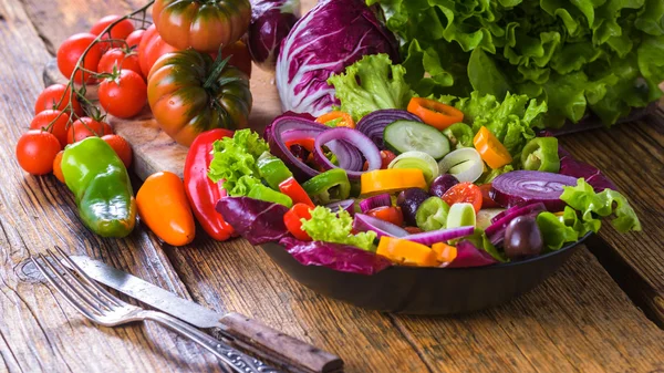 Lente salade met verse, sappige groenten op een rustieke houten tabl — Stockfoto