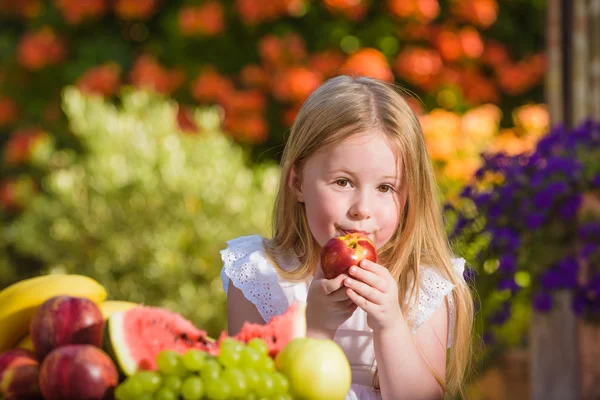 Ovocný úsměv dívku jíst vitamín v podobě nektarinek. — Stock fotografie