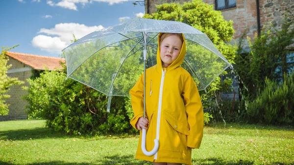 美しいブロンドの女の子は、雨の天気で遊ぶ. — ストック写真