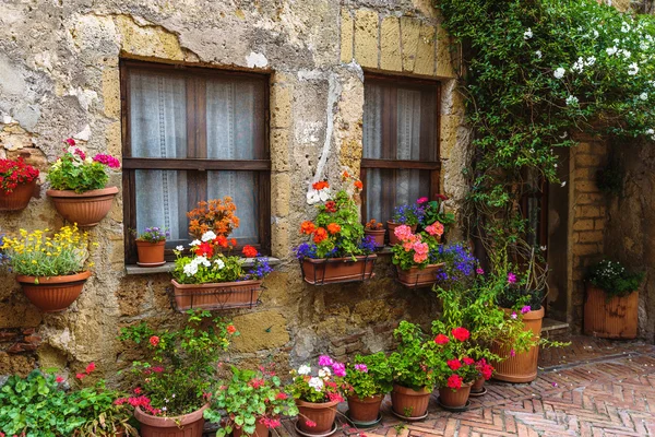 Blumengeschmückte Straßen der alten italienischen Stadt in der Toskana. — Stockfoto