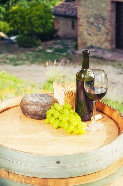 Rode wijn, pecorino kaas op een houten vat in de achtergrond-o — Stockfoto